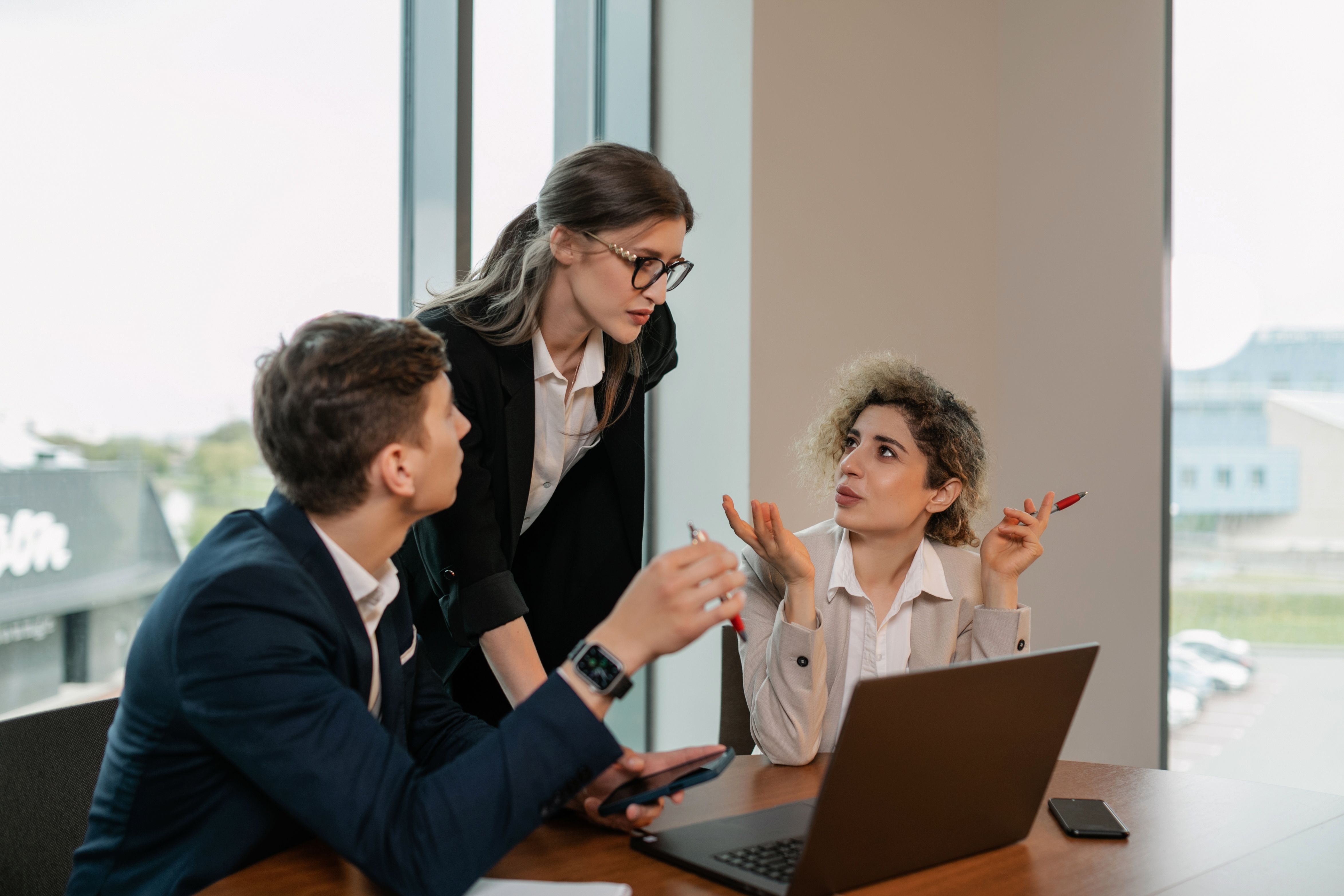 Profissionais conversando e analisando um notebook